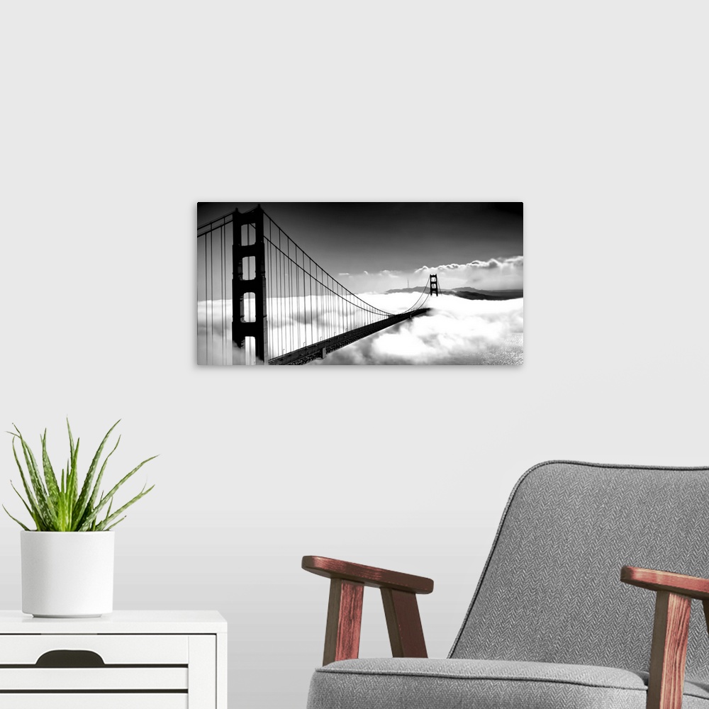A modern room featuring Black and white image of the Golden Gate Bridge in San Francisco rising above the clouds.