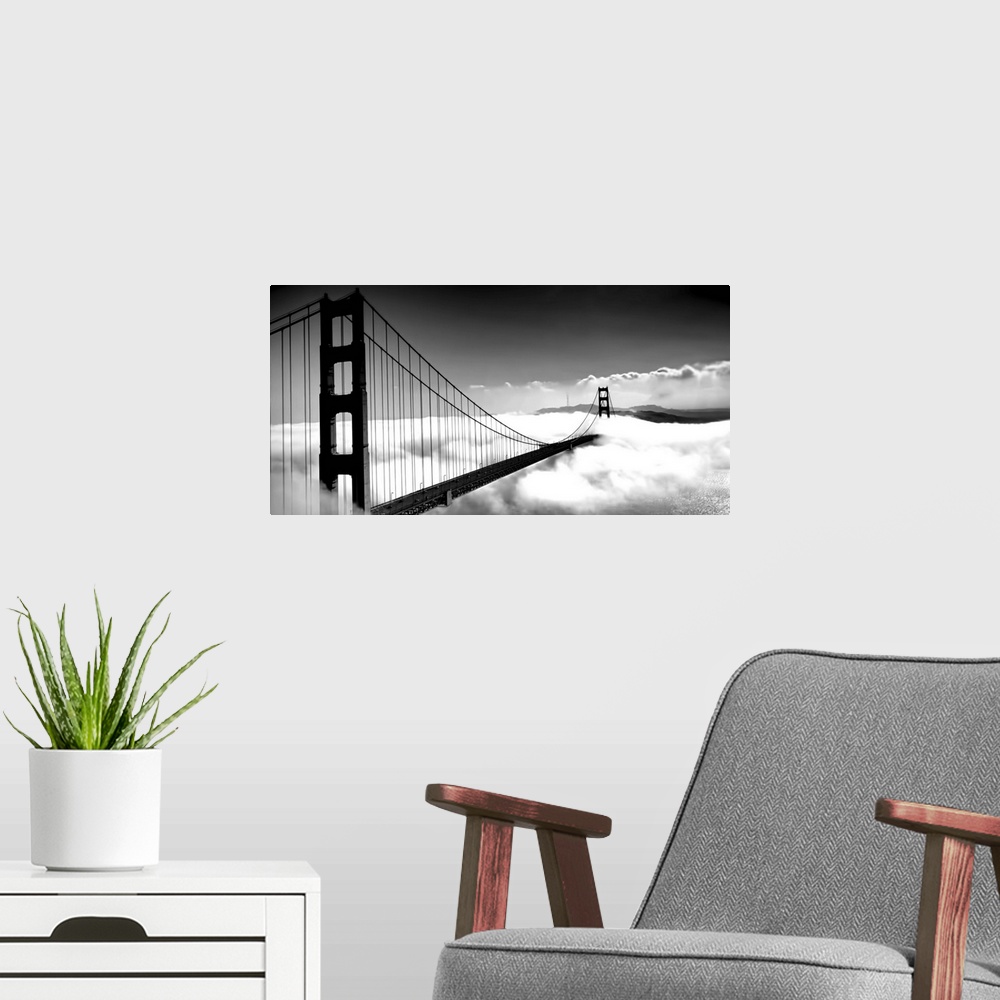 A modern room featuring Black and white image of the Golden Gate Bridge in San Francisco rising above the clouds.