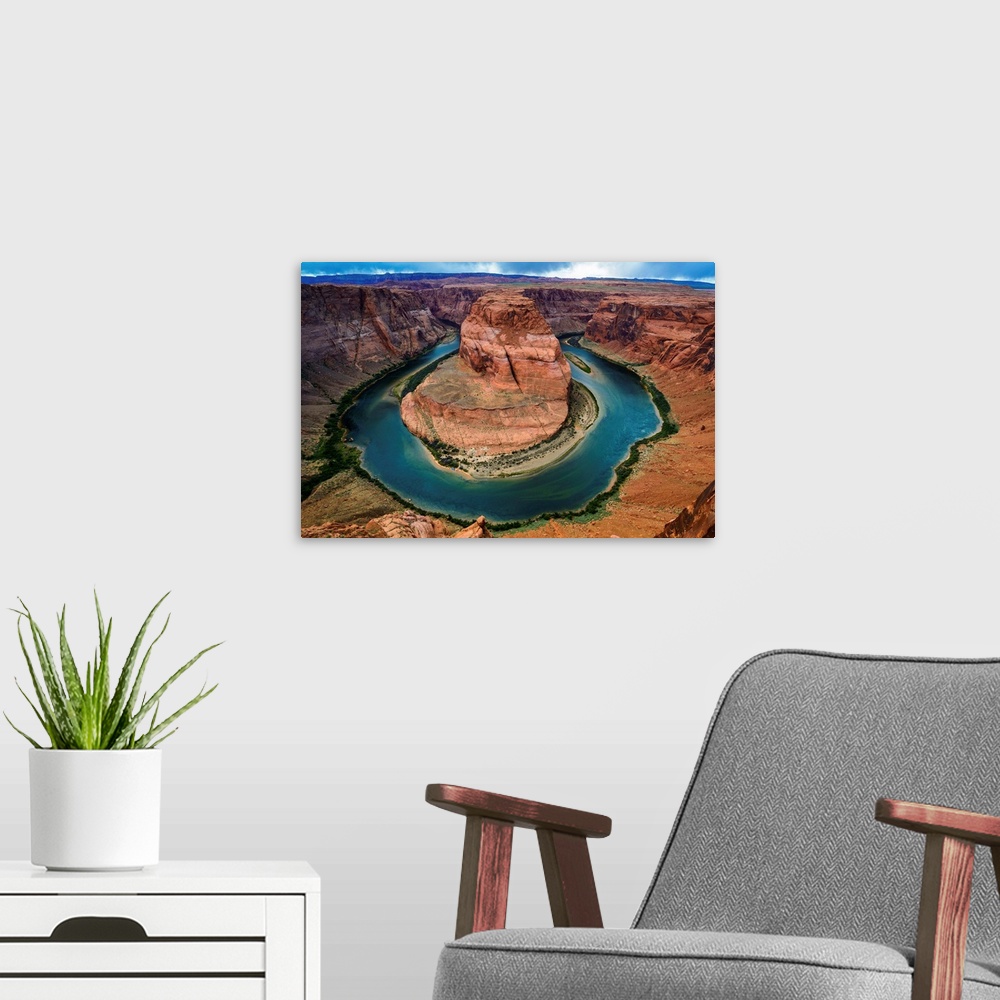 A modern room featuring Horseshoe Bend section of the Colorado River with partly cloudy skies and rain in the distance.