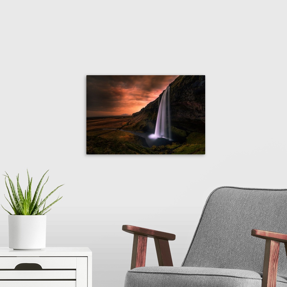 A modern room featuring Seljalandsfoss Waterfall in Southern Iceland in the evening.
