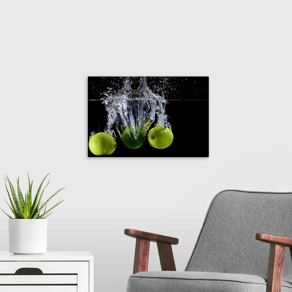 A modern room featuring Three limes splashing into clear water.