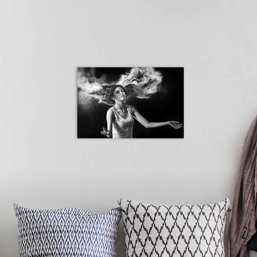 A bohemian room featuring Black and white portrait of a beautiful woman with hair swirling around her.