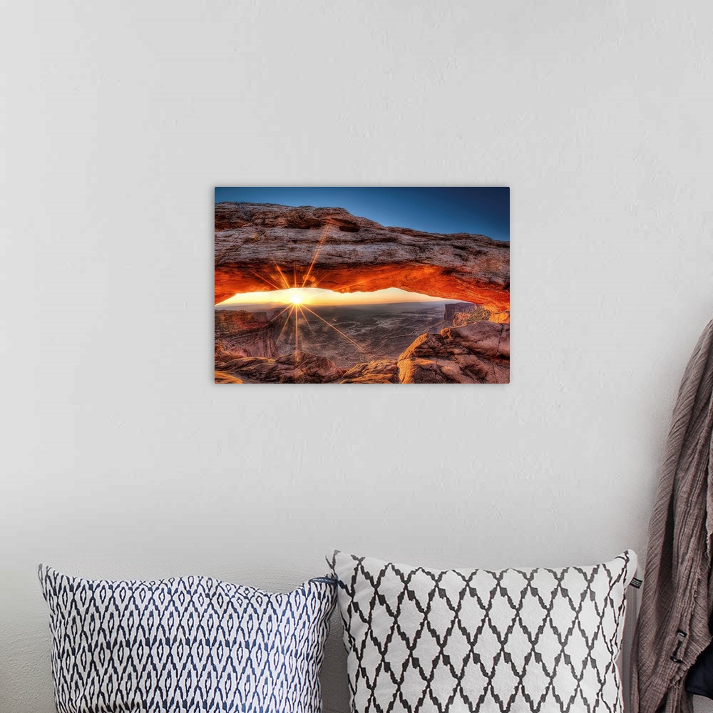 A bohemian room featuring The sun rises in Canyonlands National Park and for a brief moment illuminates the breathtaking Me...