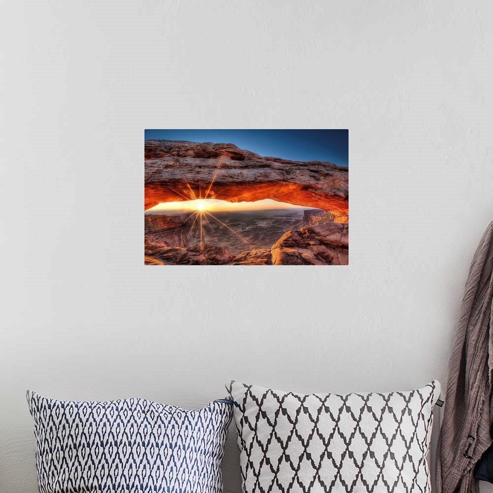 A bohemian room featuring The sun rises in Canyonlands National Park and for a brief moment illuminates the breathtaking Me...