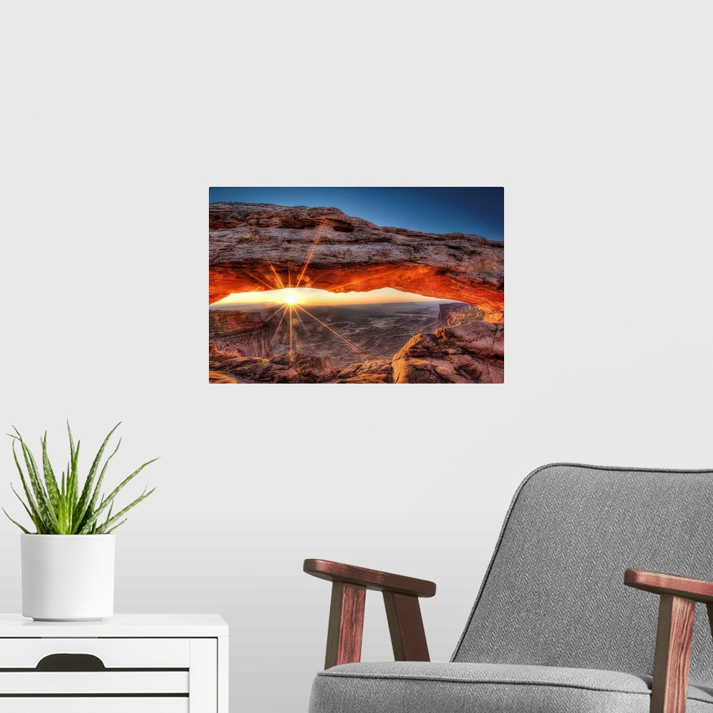 A modern room featuring The sun rises in Canyonlands National Park and for a brief moment illuminates the breathtaking Me...