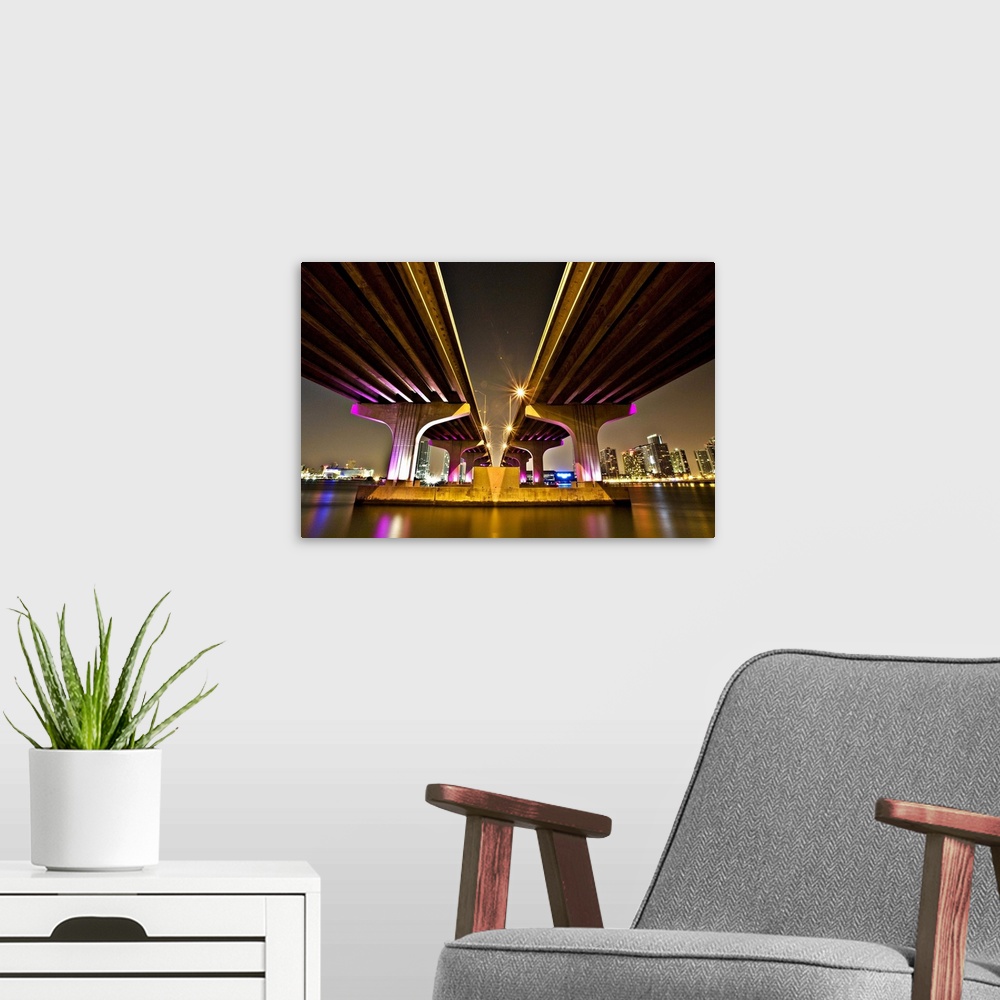 A modern room featuring Dynamic photograph of two overpasses leading to Miami, glowing from neon lights.