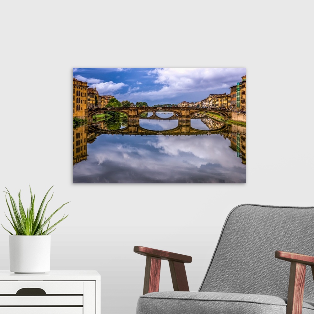 A modern room featuring Ponte Vecchio bridge in Florence, Italy, with a mirror reflection in the Arno River.