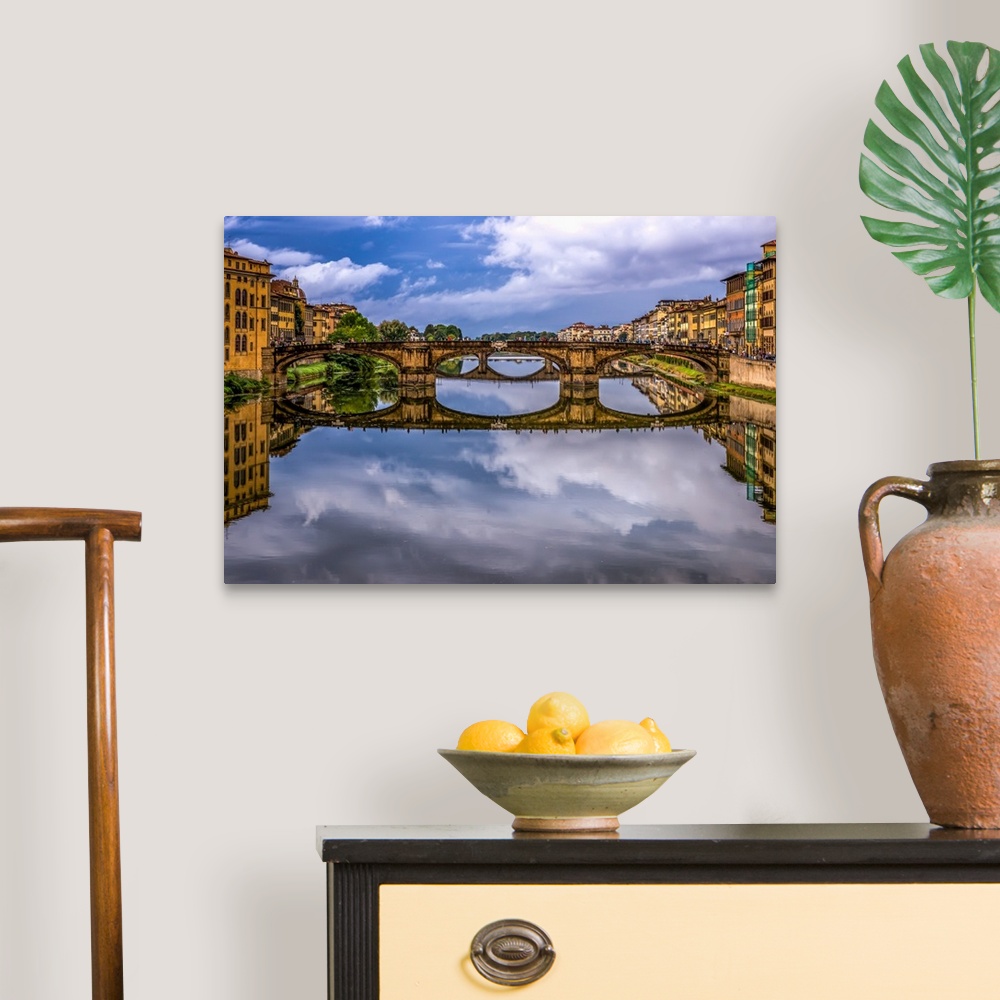 A traditional room featuring Ponte Vecchio bridge in Florence, Italy, with a mirror reflection in the Arno River.