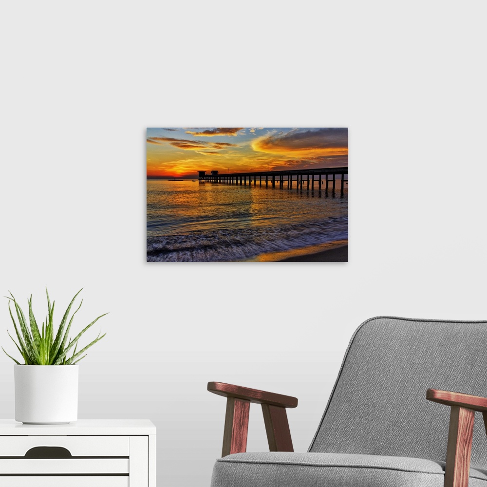 A modern room featuring Sunrise over the water from a beach.