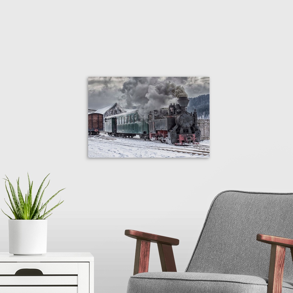 A modern room featuring A steam locomotive going down the tracks in the snow.