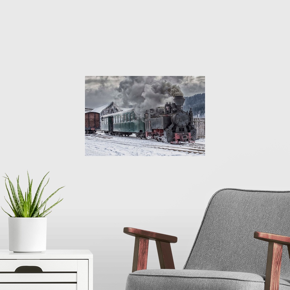 A modern room featuring A steam locomotive going down the tracks in the snow.