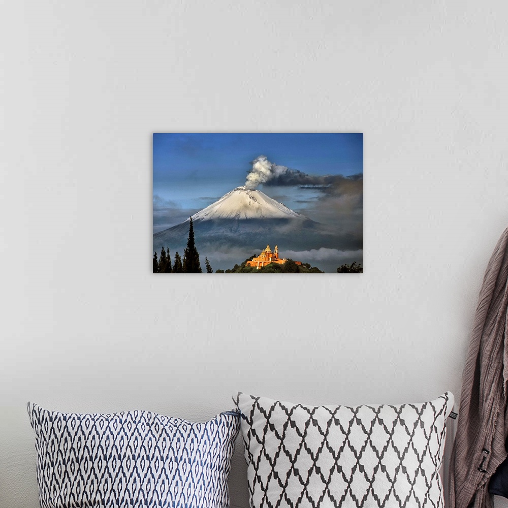 A bohemian room featuring Popocatepetl, snowy and smoking with Choluula church in the foreground.