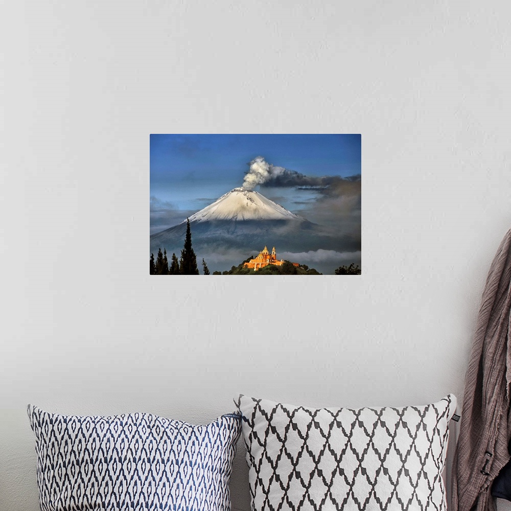 A bohemian room featuring Popocatepetl, snowy and smoking with Choluula church in the foreground.