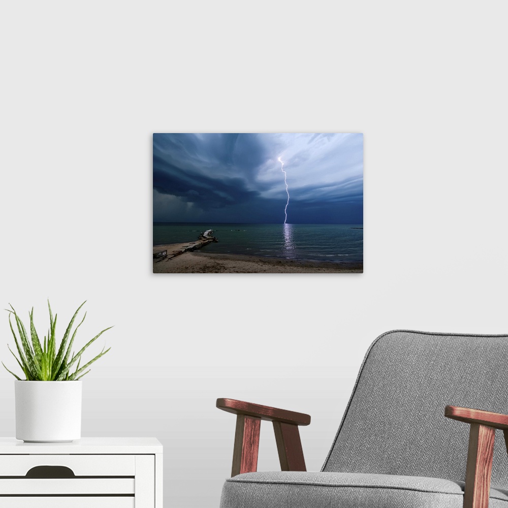 A modern room featuring Photograph of a lightning strike over water.