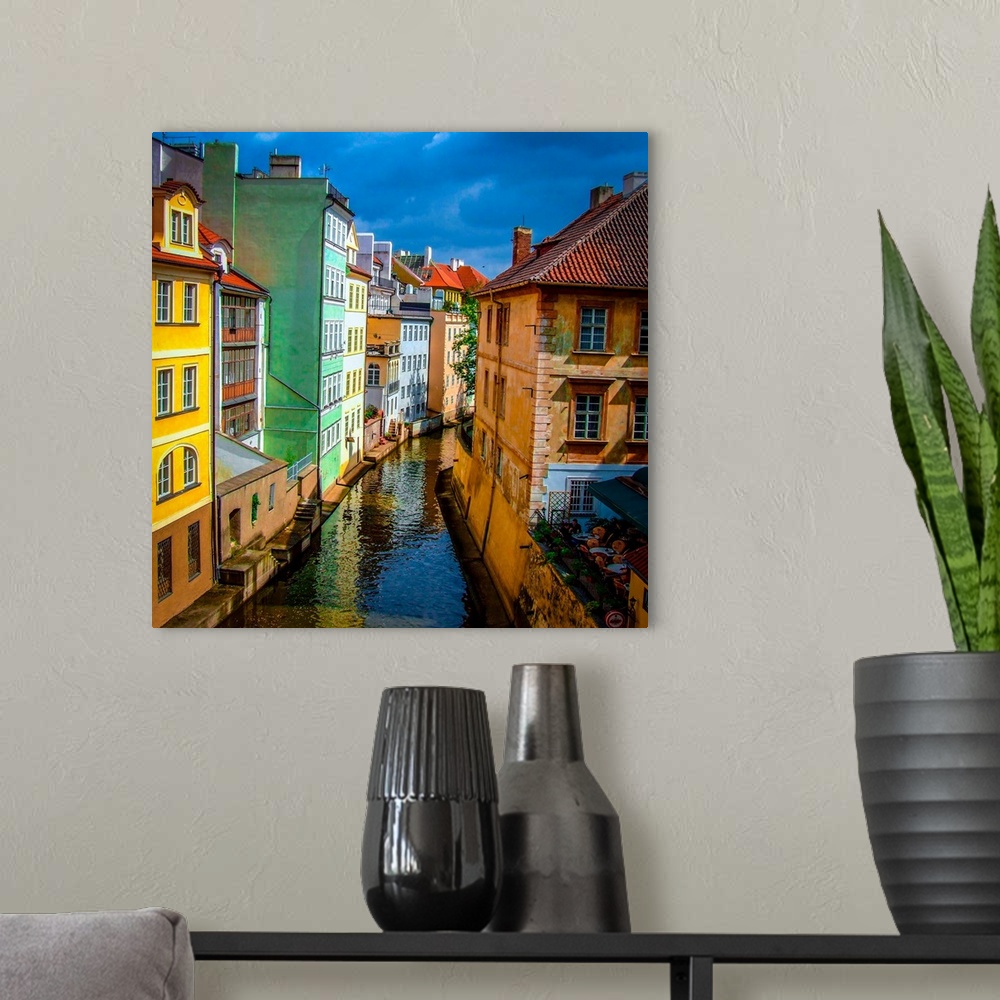 A modern room featuring Colorful buildings along the canal in Prague.
