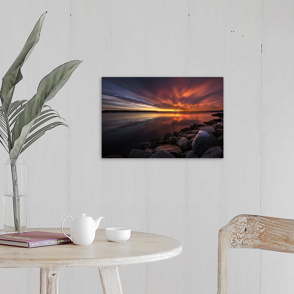 A farmhouse room featuring Beautiful sunset colors and dramatic clouds over a rocky beach.