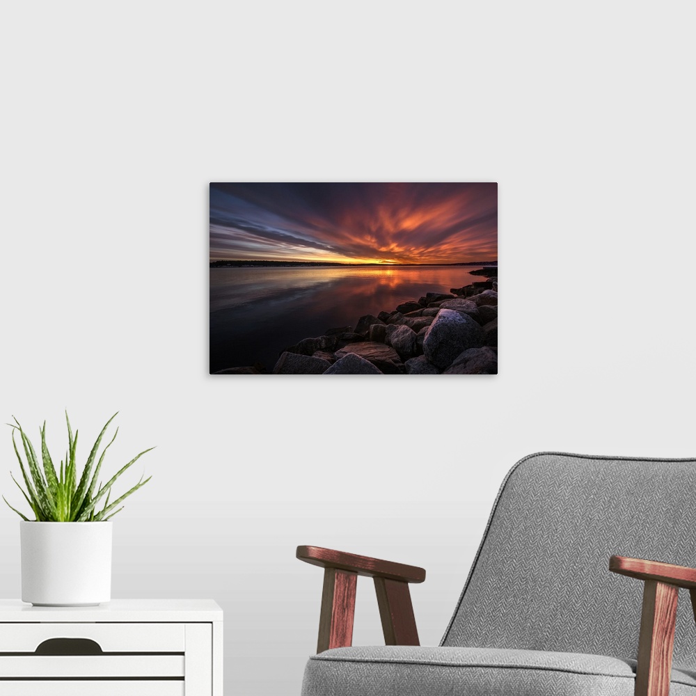 A modern room featuring Beautiful sunset colors and dramatic clouds over a rocky beach.