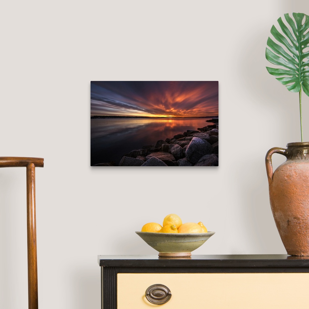 A traditional room featuring Beautiful sunset colors and dramatic clouds over a rocky beach.