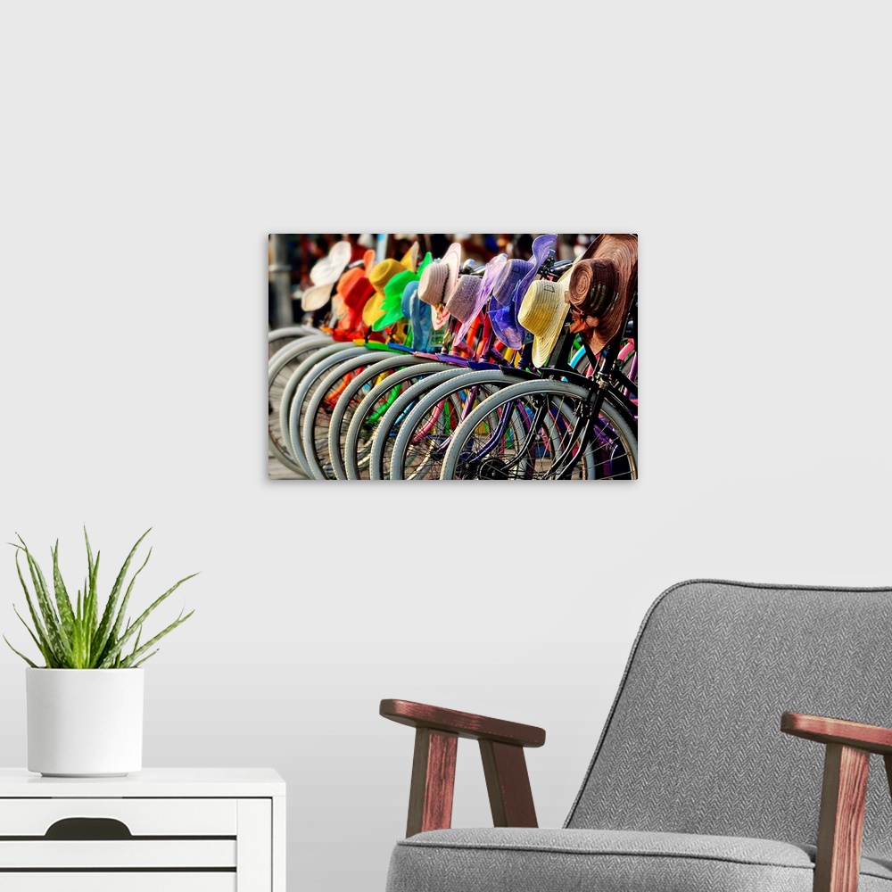 A modern room featuring A row of bicycles with rainbow hats hanging on the handlebars.