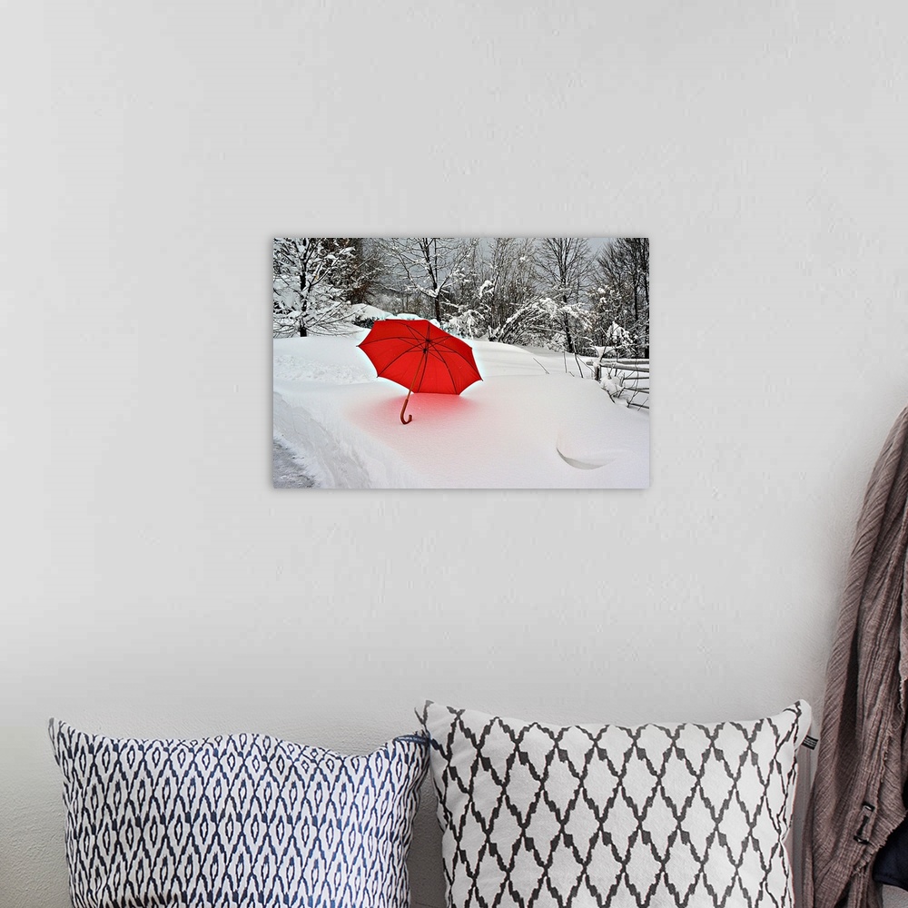 A bohemian room featuring A bright red umbrella stands out against the white snowscape.