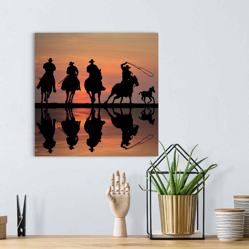 A bohemian room featuring Silhouettes of four cowboys on horseback at sunset, roping a foal.
