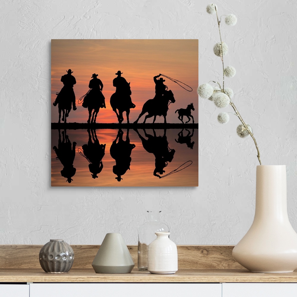 A farmhouse room featuring Silhouettes of four cowboys on horseback at sunset, roping a foal.