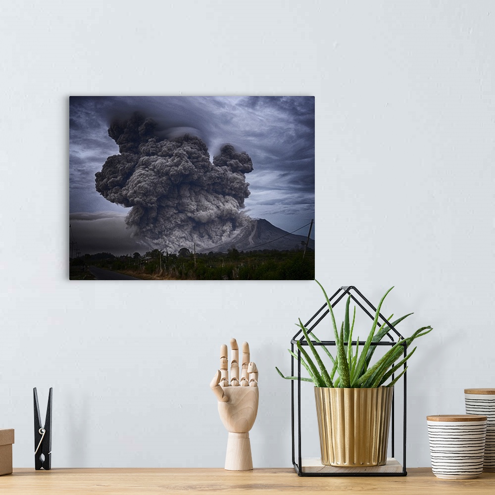 A bohemian room featuring Dramatic photograph of an intense plume of smoke rising from the mouth of a volcano in Indonesia.