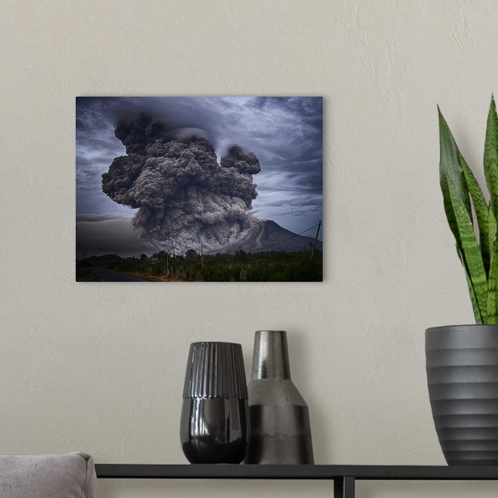 A modern room featuring Dramatic photograph of an intense plume of smoke rising from the mouth of a volcano in Indonesia.