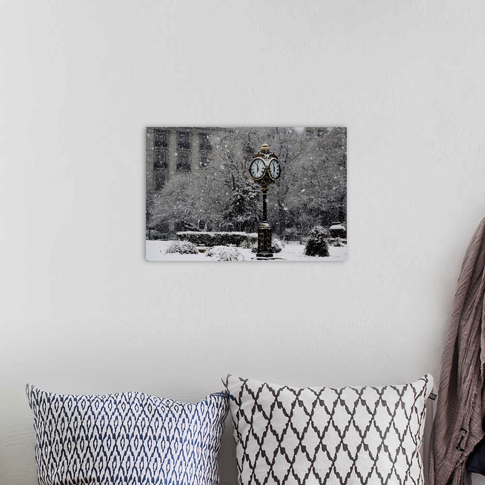 A bohemian room featuring A large clock standing in a park while snow falls around it.