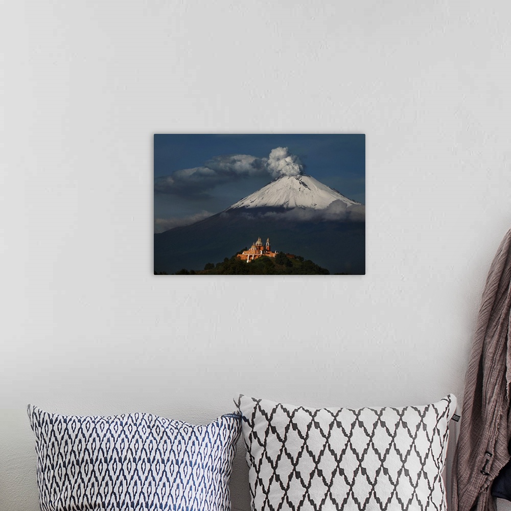 A bohemian room featuring Photograph of a volcano with smoke pluming out of the top.