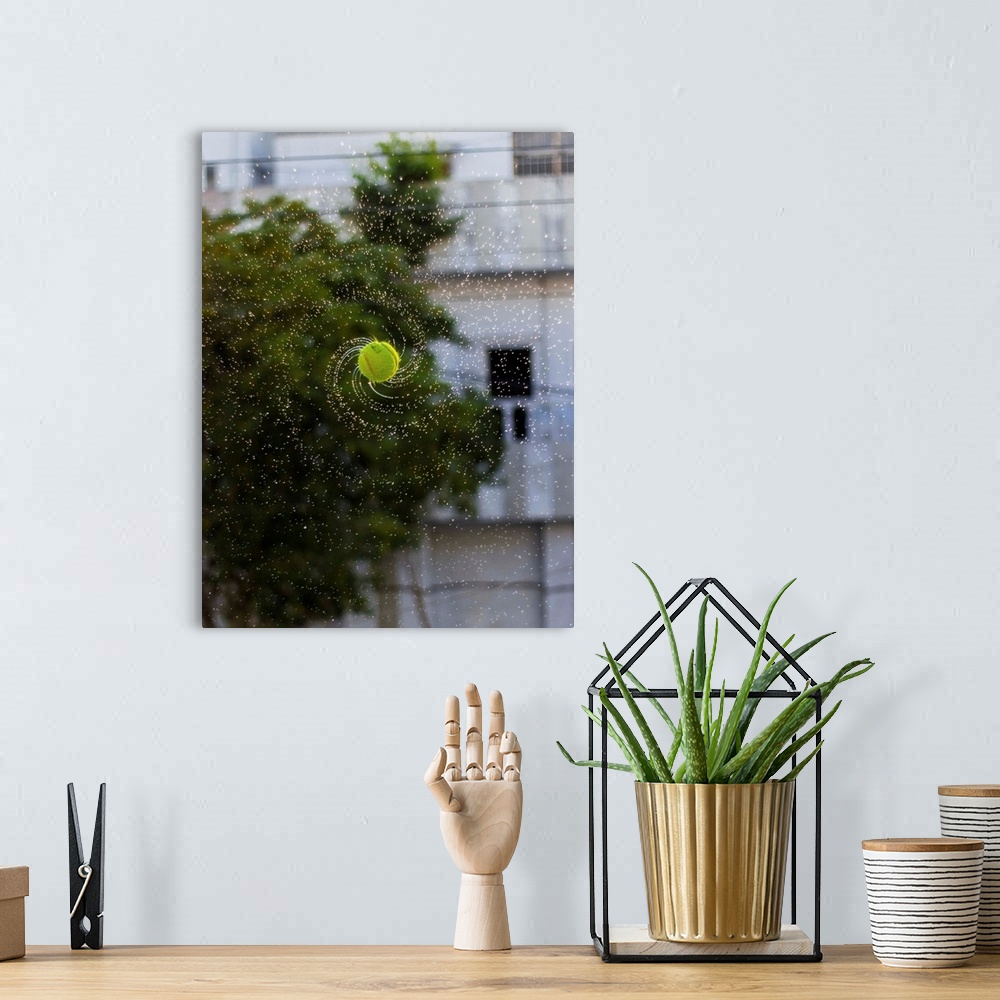 A bohemian room featuring Photograph of a tennis ball spinning with water streaming off it.