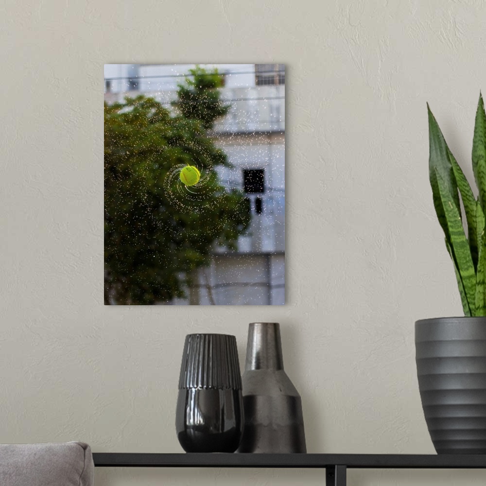 A modern room featuring Photograph of a tennis ball spinning with water streaming off it.
