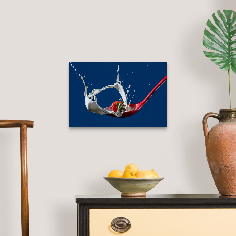 A traditional room featuring High-speed shot of a strawberry splashing into a ladle of cream.