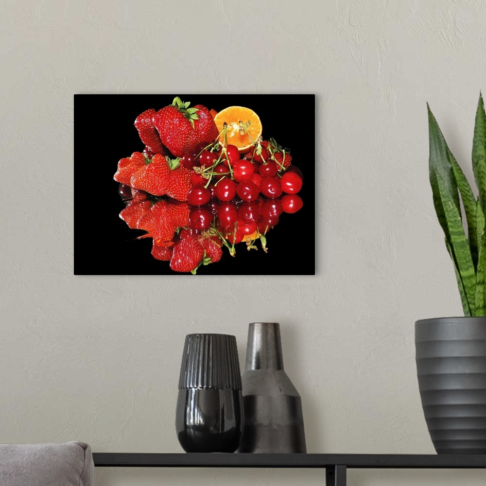 A modern room featuring A group of red fruits including strawberries, cherries, and a slice of orange, on a mirror.