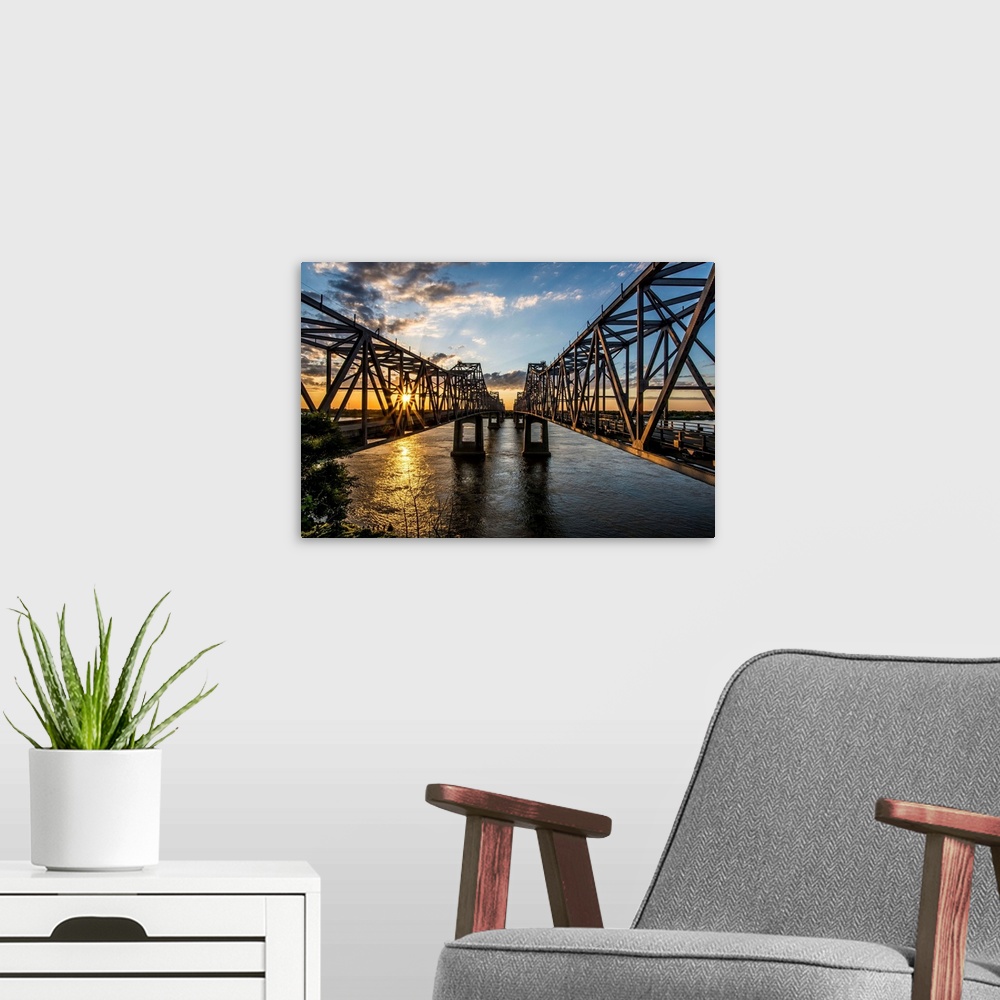 A modern room featuring Light from the setting sun on the Natchez Bridges over the Mississippi River.