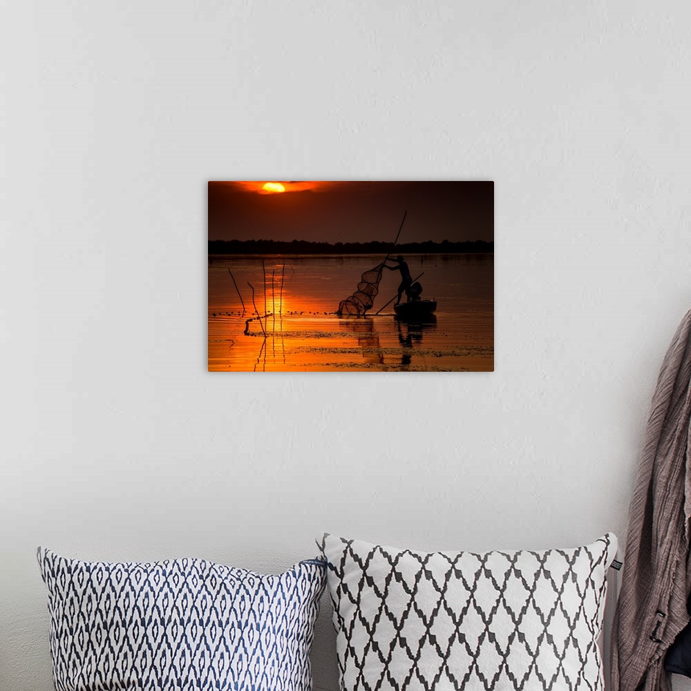 A bohemian room featuring A fisherman from Danube Delta, Romania at sunset.