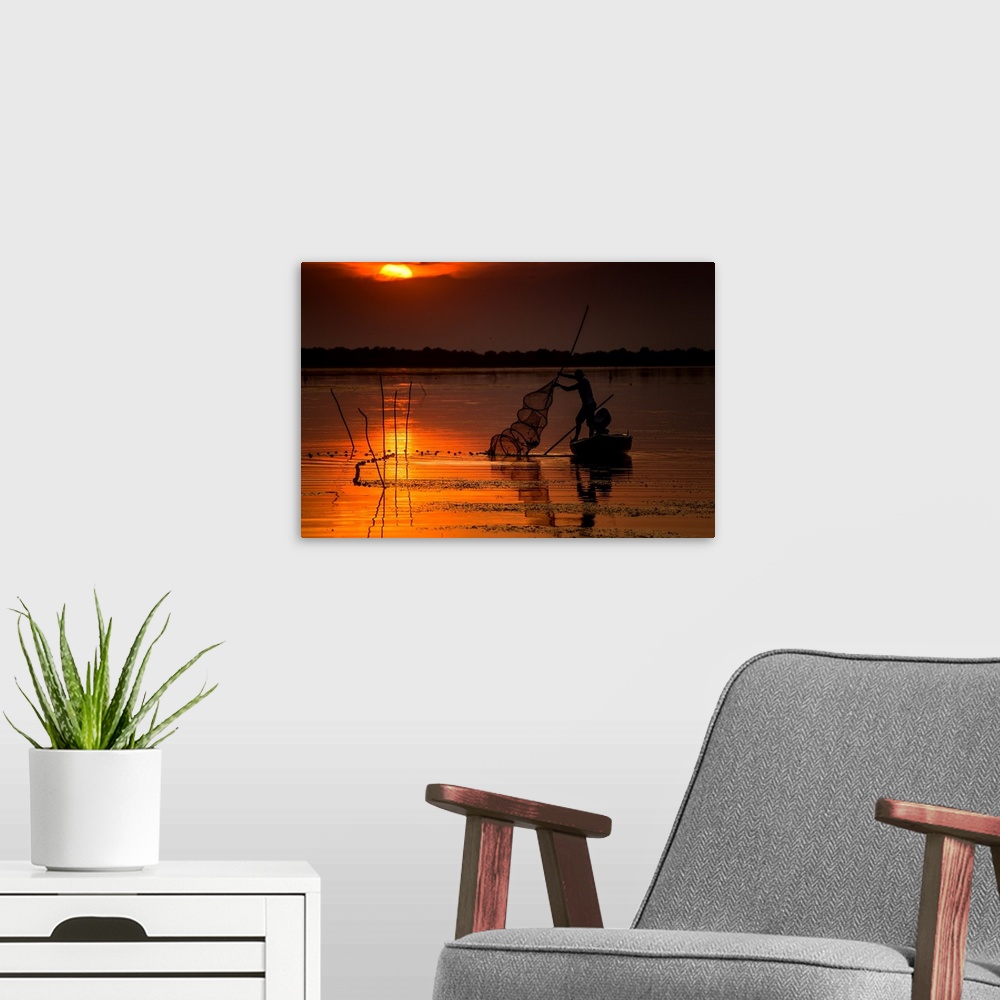 A modern room featuring A fisherman from Danube Delta, Romania at sunset.