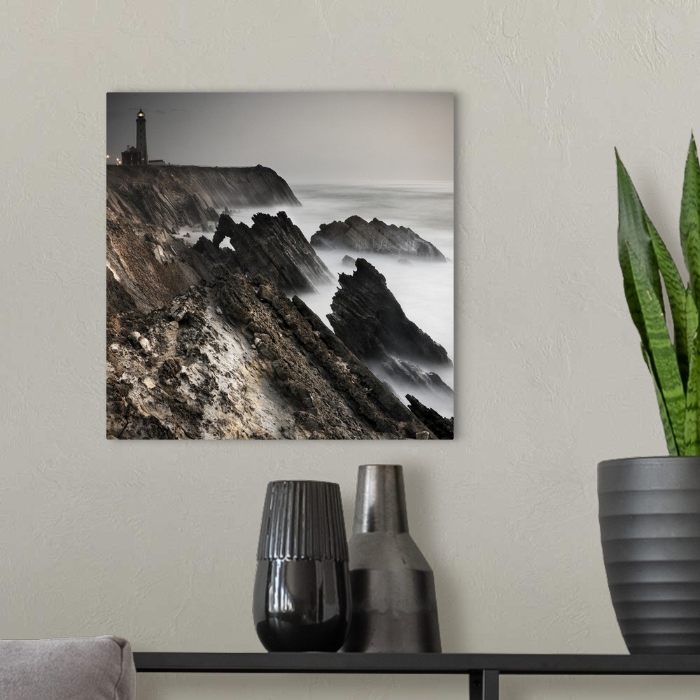 A modern room featuring Dynamic photograph of a lighthouse on a foggy jagged rocky coast.