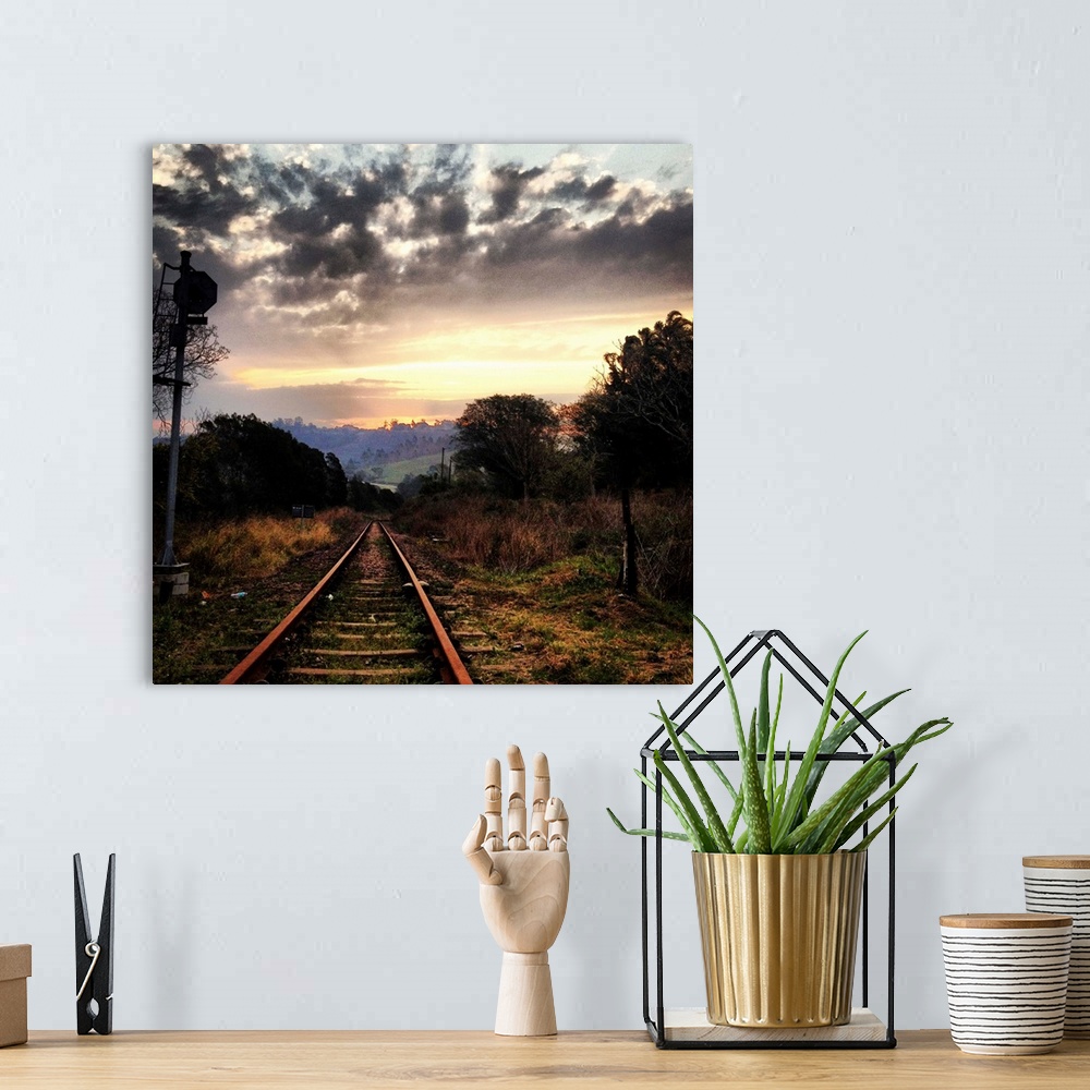 A bohemian room featuring Railway line leading into the setting sun, beautiful dramatic sky.