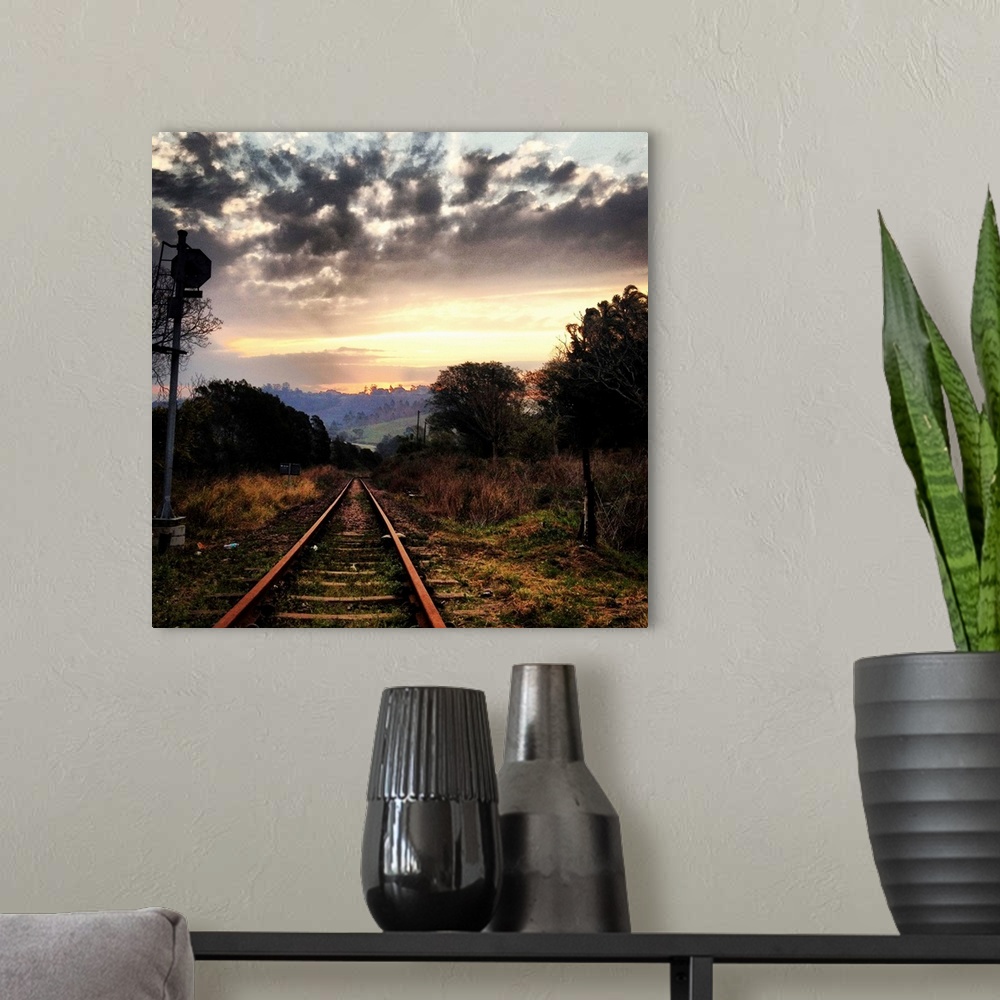 A modern room featuring Railway line leading into the setting sun, beautiful dramatic sky.