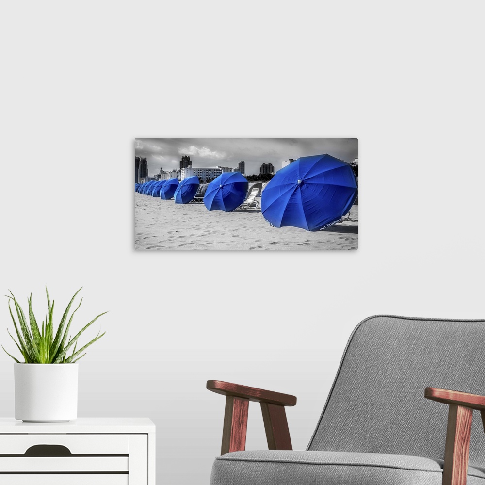 A modern room featuring Blue beach umbrellas in the sand at the beach in Miami, Florida.