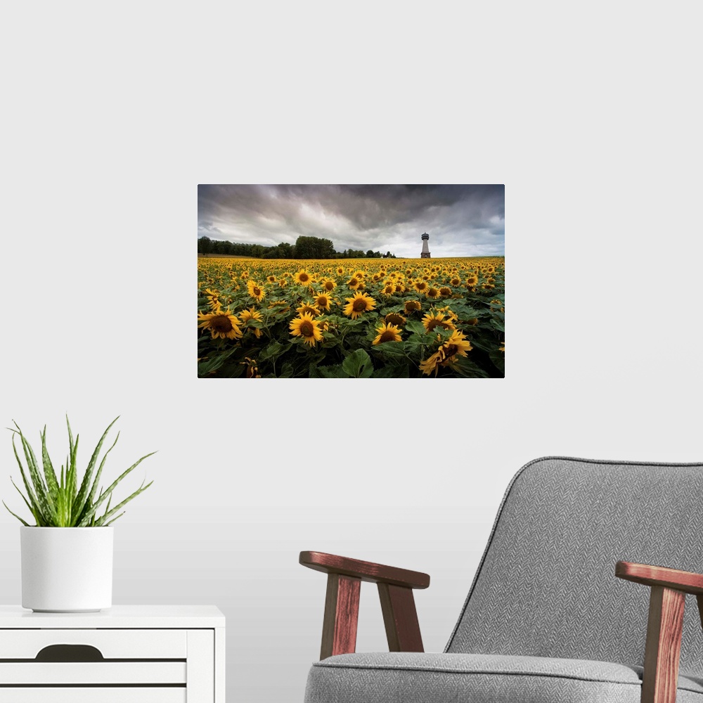A modern room featuring A tower stands above a field of sunflowers under a cloudy sky.