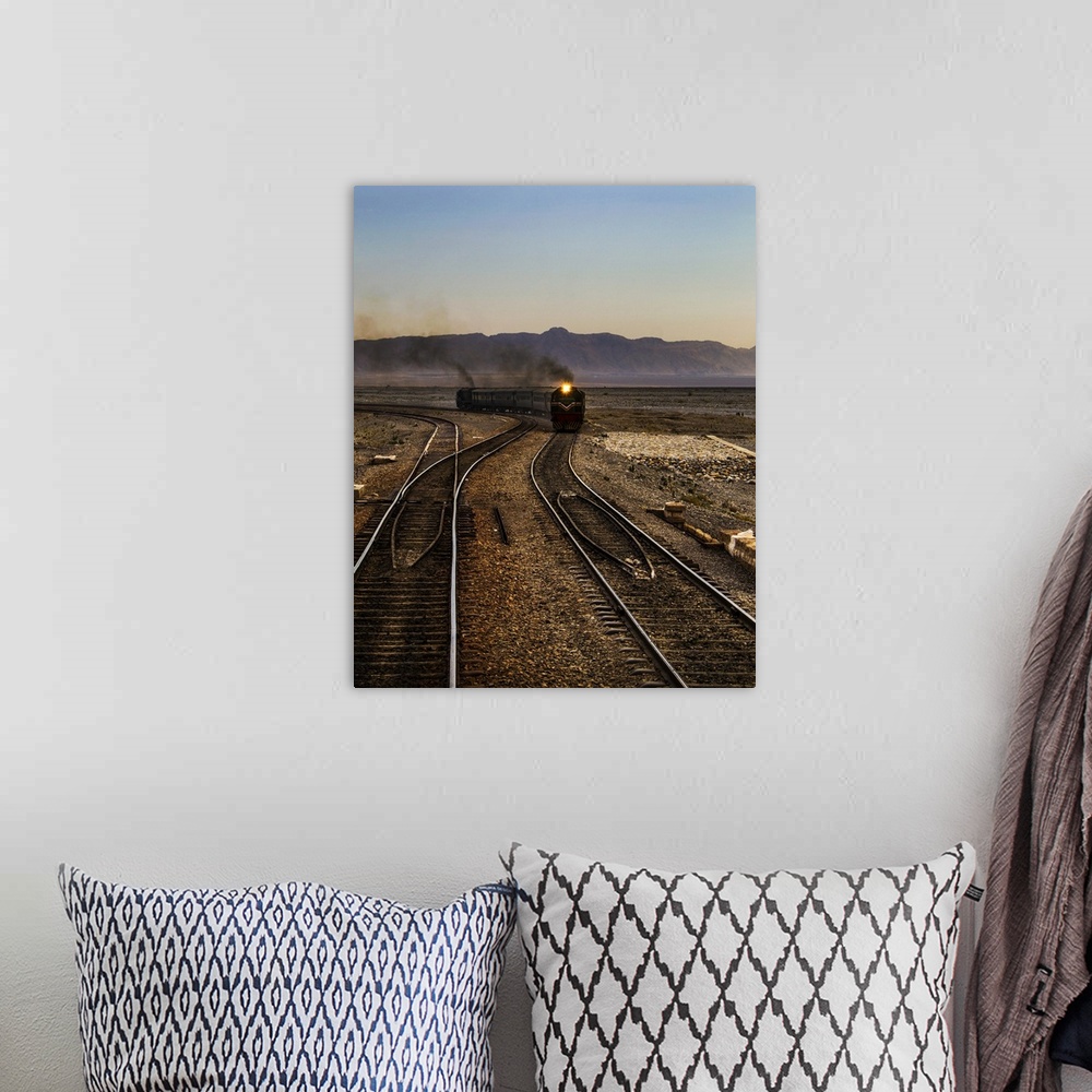 A bohemian room featuring A train approaching on the railroad tracks in the late afternoon.