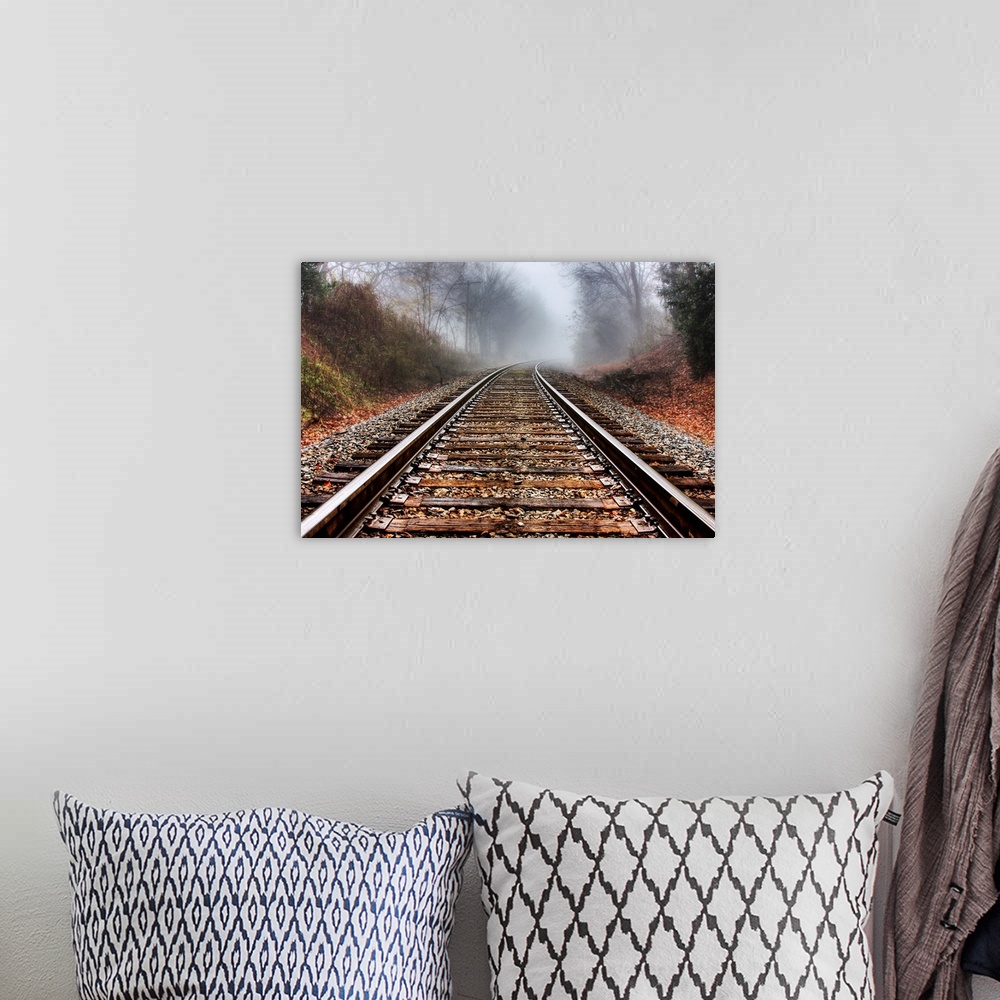 A bohemian room featuring Railroad tracks leading into the fog in the morning.