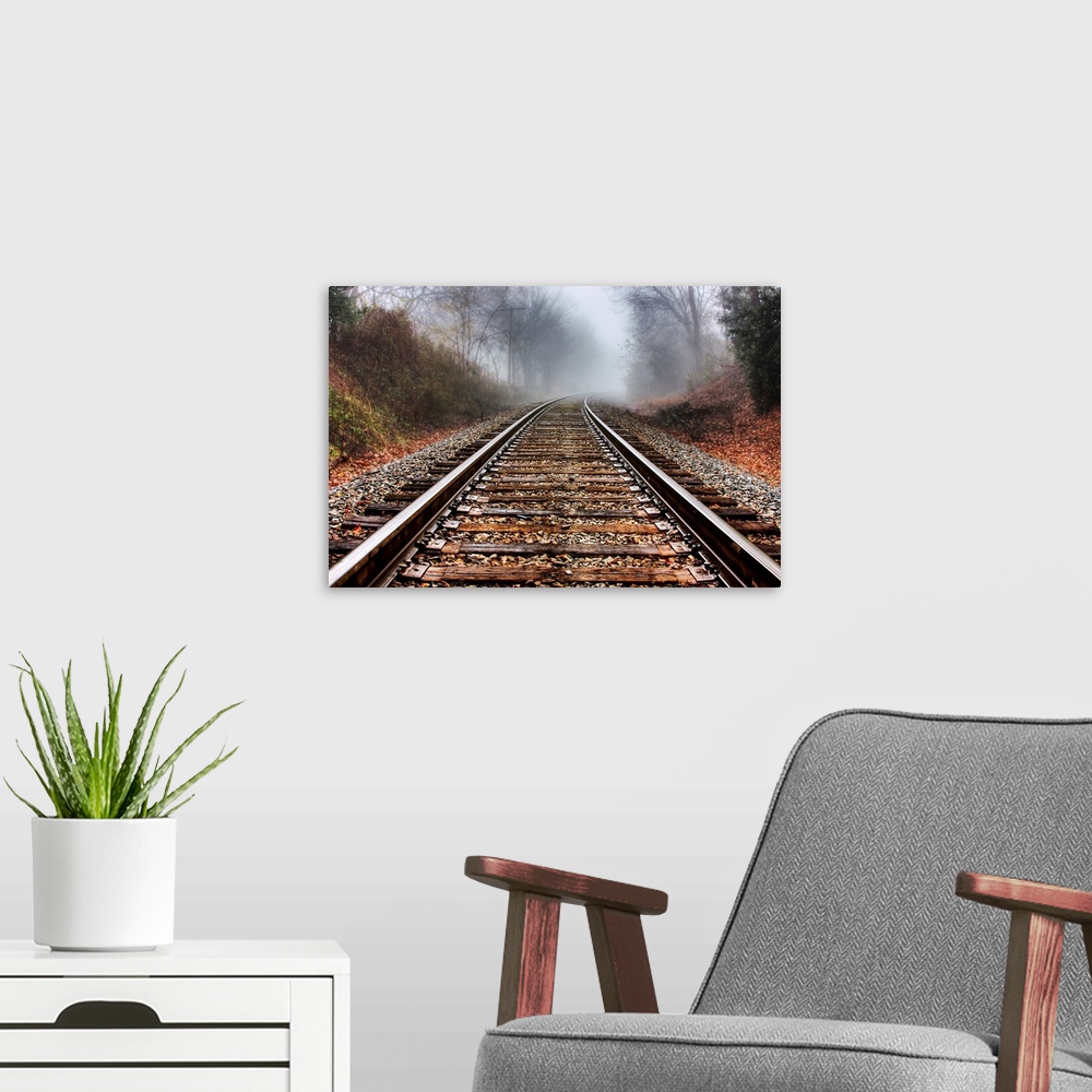 A modern room featuring Railroad tracks leading into the fog in the morning.