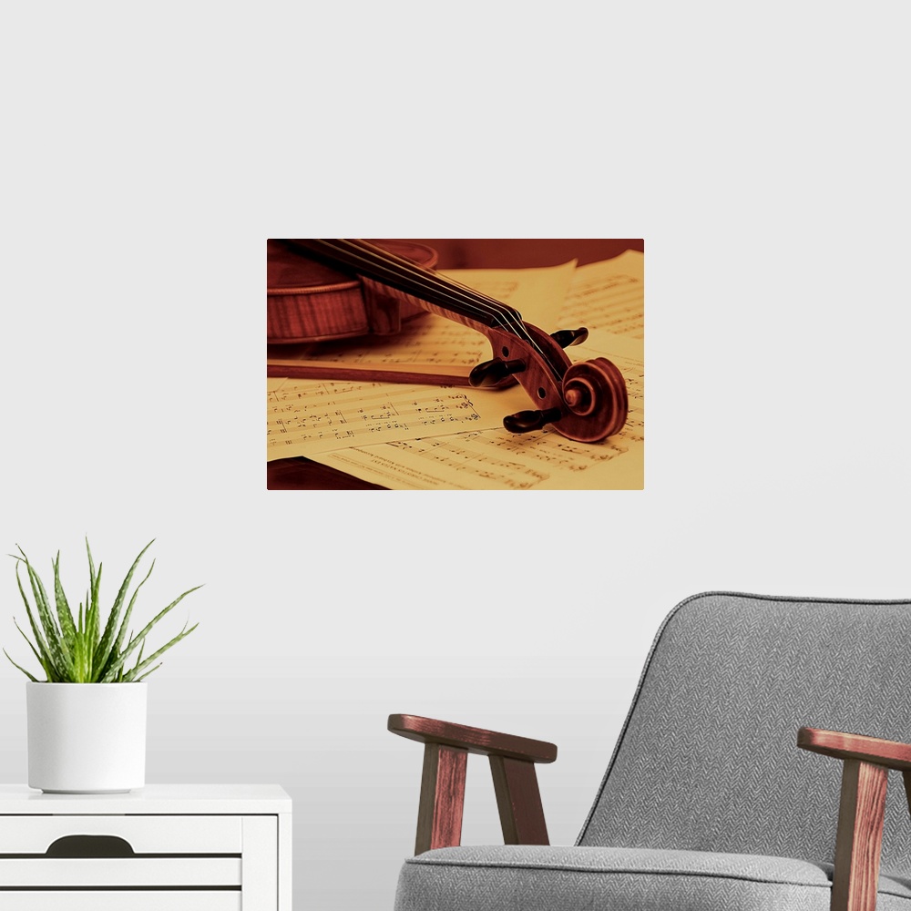 A modern room featuring The head of a violin resting on sheet music.