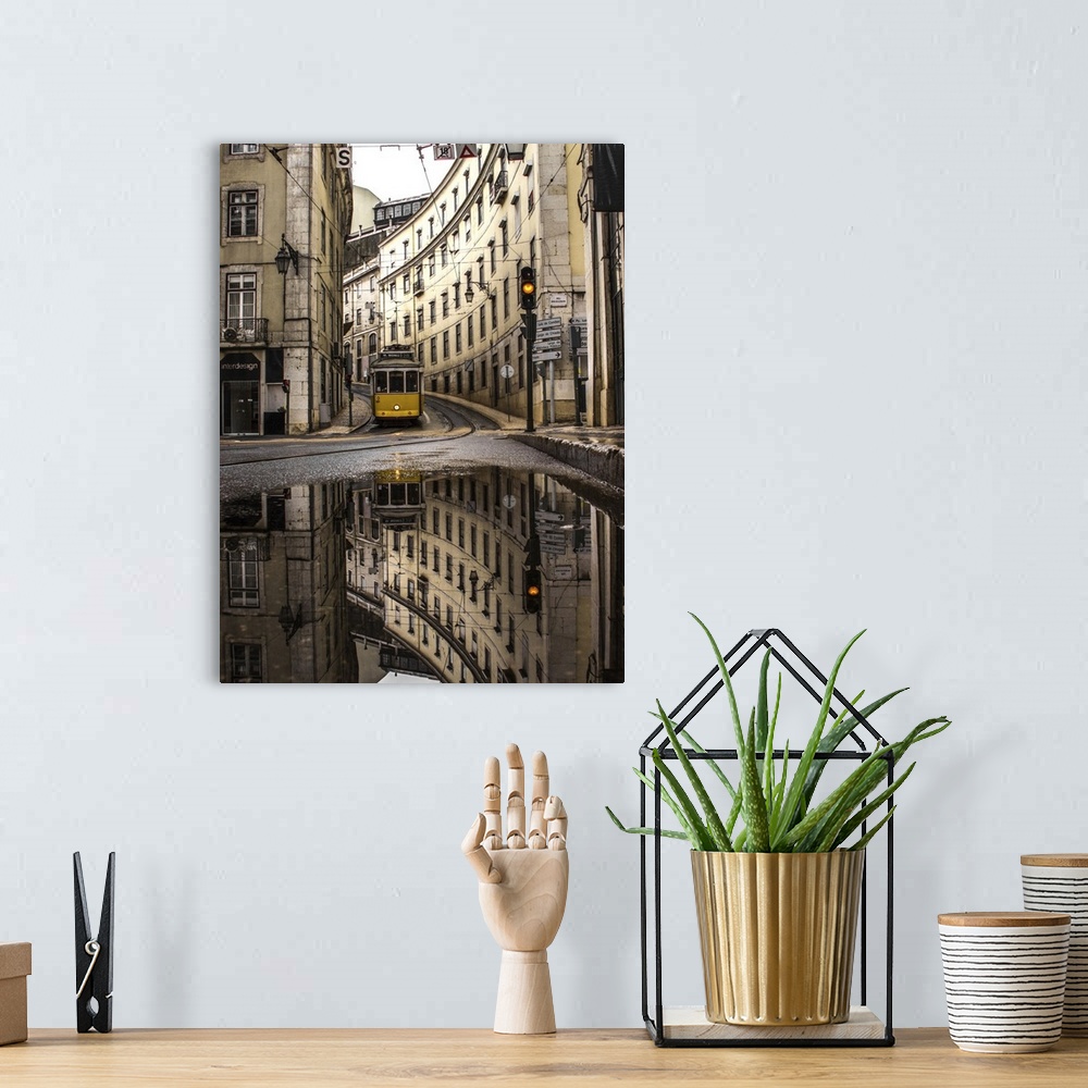 A bohemian room featuring An old street of Lisbon with a yellow train coming. Yellow traffic light. The street view reflect...