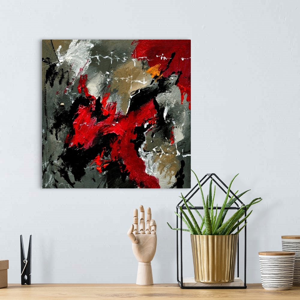 A bohemian room featuring A square abstract painting with deep textured colors of red and gray.
