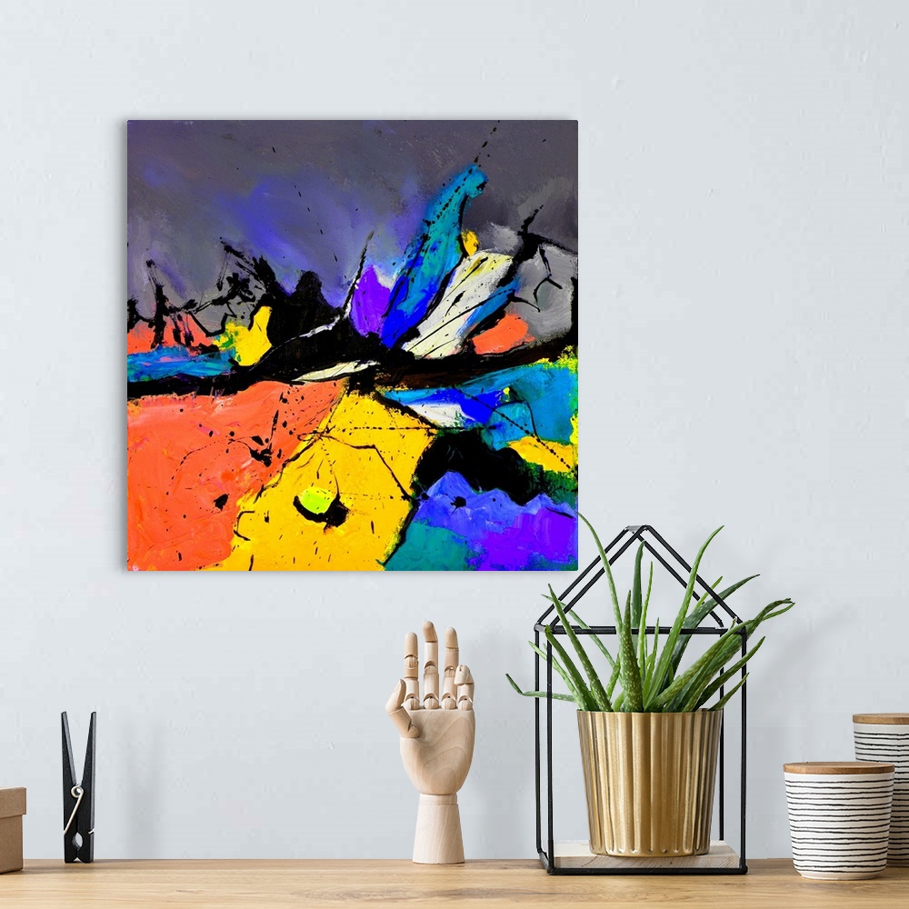A bohemian room featuring A square abstract painting in vibrant shades of orange, blue, purple and yellow with splatters of...