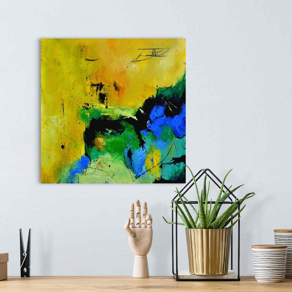 A bohemian room featuring A square abstract painting in shades of green, blue, white and yellow with splatters of paint ove...